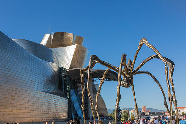 Bilbao, Spain - October 29, 2016; Back of the Guggenheim Museum, contemporary art, work of the Canadian architect Frank O. Gehry, and the sculpture of the spider of Louise Bourgeois. There  are people walking